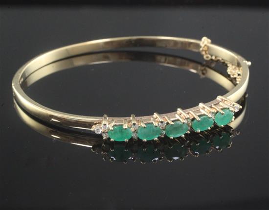 A 9ct gold, emerald and diamond hinged bangle,